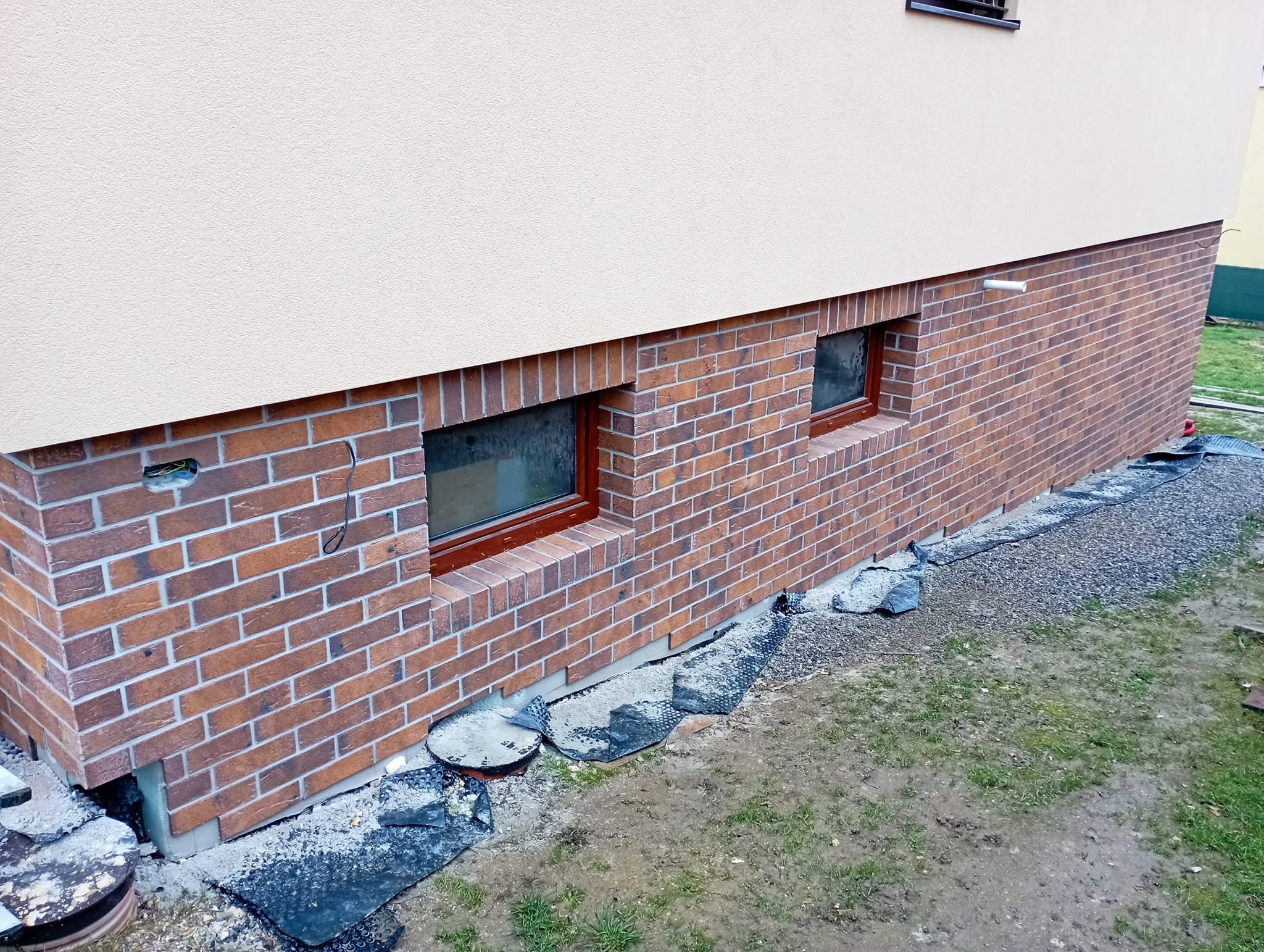 Murár opravuje omietku na stene domu